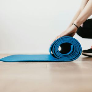 An empty yoga mat on a wooden floor.